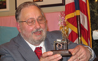 Students present Ron Tedesco with a wire sculpture that represents his years as a science teacher.