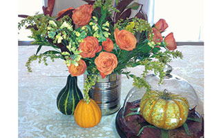 A repurposed tin can pairs  wonderfully with autumn foliage and simple gourds, while a  glass cloche makes even a humble pumpkin seem like treasure.  