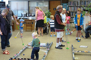 Children and adults enjoying themselves at Warner Library's Headless Halloween Mini-Golf event.