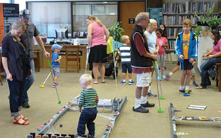 Children and adults enjoying themselves at  Warner Library's Headless Halloween Mini-Golf event.