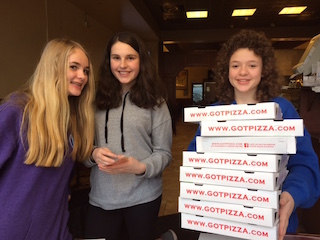 Middle school students place stickers on boxes at Nick’s Pizza & Capri Pizza.