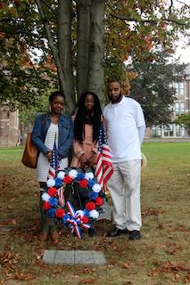 Shayla Wyche, Craig Wyche’s cousin; niece Kijafa Alston; and brother Glenn Wyche stand by the tree and memorial plaque at Ossining High School